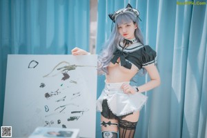 A woman in a maid outfit posing in front of a piano.