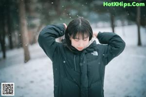 A woman wearing a face mask standing in the snow.