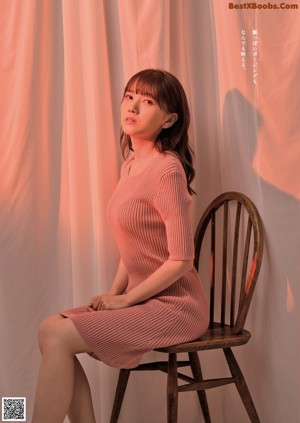 A woman in a blue top is posing for a picture.