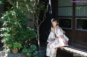 A naked asian woman sitting on top of a bed.