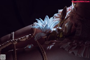 A woman laying on top of a bed covered in red flowers.