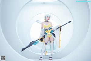 A woman in a bikini sitting on a ledge with a sword.