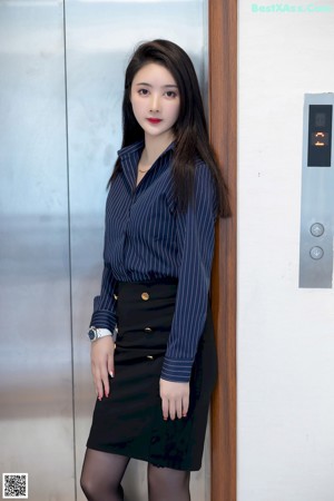 A woman sitting on the floor in an elevator.