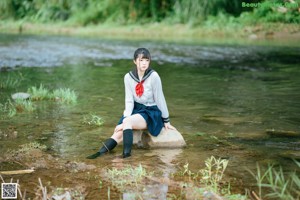 A woman in a sailor outfit standing in the water.