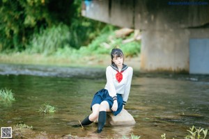 A woman in a sailor outfit sitting in the water.