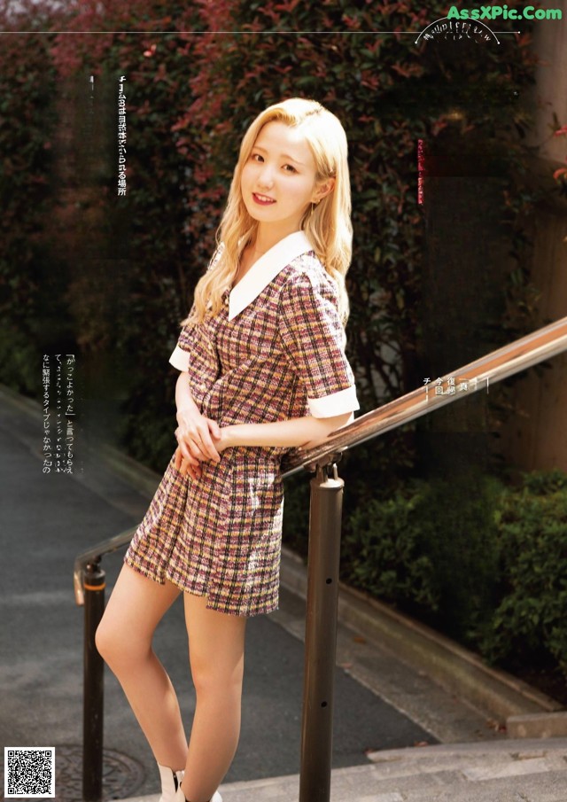 A woman in a plaid dress is posing for a magazine.