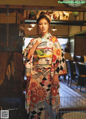 A woman in a green dress sitting on a bench.