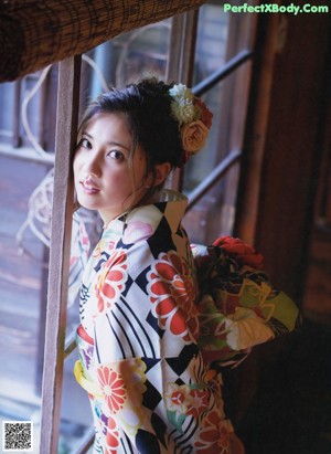 A woman in a kimono standing in front of a building.