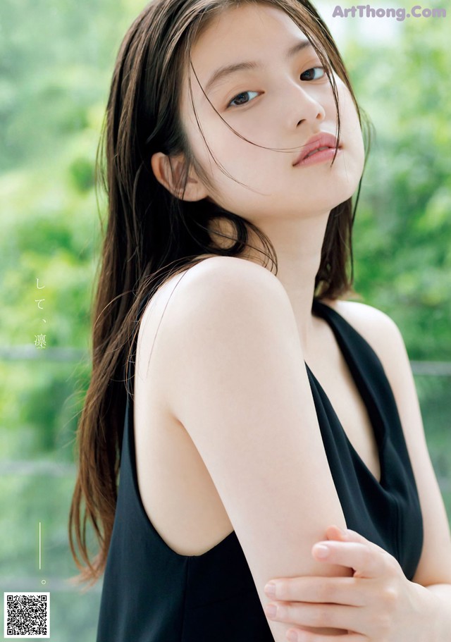 A woman in a black dress posing for a magazine.