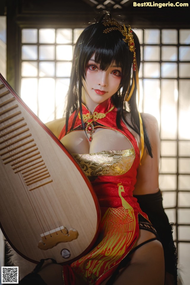 A woman in a red and gold outfit holding a musical instrument.