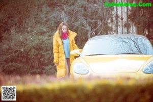 a woman in a yellow jacket is sitting on a chair