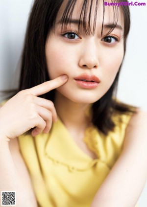 A woman in a yellow dress posing for a magazine.