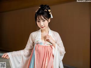 A woman in a white robe sitting in a bathtub.