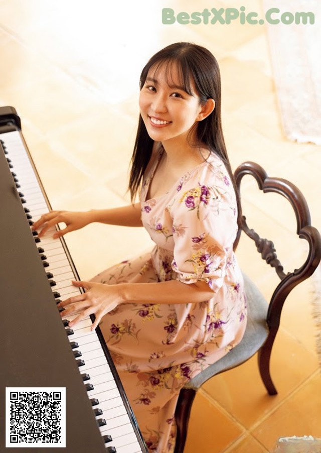 A woman sitting on a chair playing a piano.