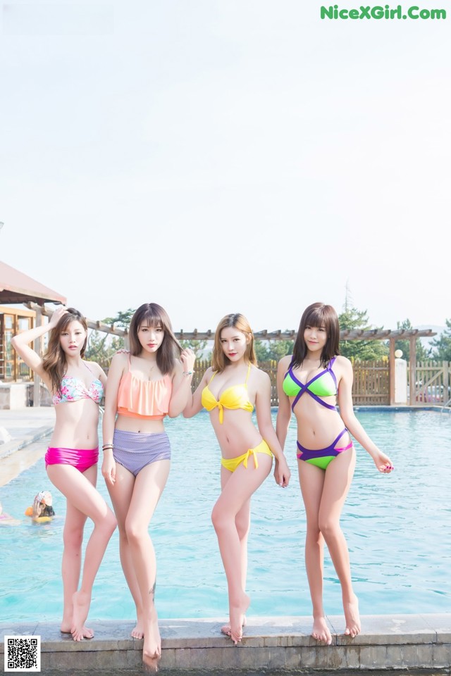 A group of young women standing next to a swimming pool.