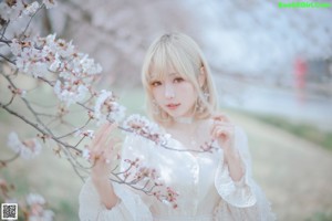 A woman in a white dress standing in a field of flowers.