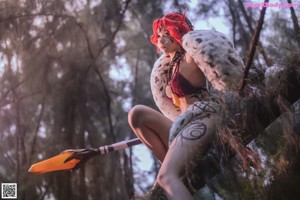 A woman with red hair holding a bow and arrow.