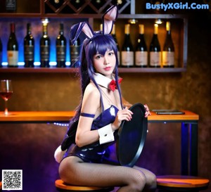 A woman sitting on a stool in a bar.