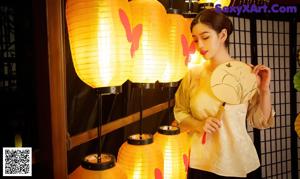 a woman sitting on a chair in front of a bunch of lanterns