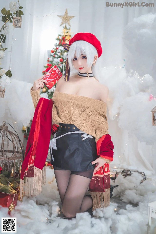 A woman in a red beret is posing in front of a Christmas tree.