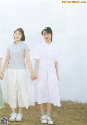 A group of young women laying on top of a bed.