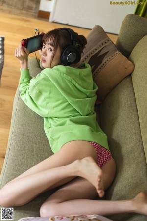 A woman laying on the floor playing a video game.