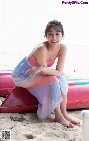 A woman in a white dress standing on a pier.