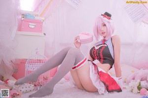 A woman in a maid outfit holding a pink box.