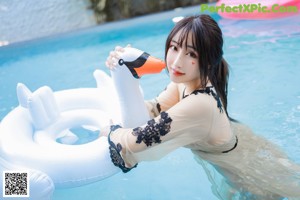 A woman in a sheer dress is standing in a pool.