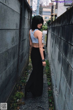 A woman standing in a hallway with her hands on her hips.