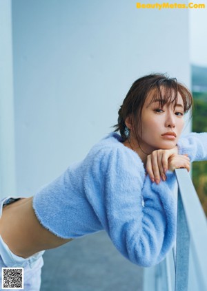 A woman sitting on the floor in front of a window.