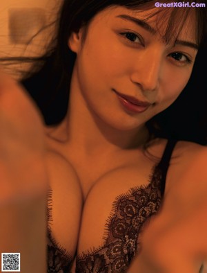 A woman in a lingerie sitting on the floor.